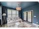Comfortable sun room features a white couch, blue walls and curtains, and french doors at 4931 Pauls Pointe, Sugar Hill, GA 30518