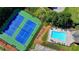 Aerial view of tennis courts and a community pool, surrounded by greenery and trees at 1901 Paper Birch Cv, Grayson, GA 30017