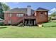 Spacious backyard features a brick home with a deck, stairs, and outdoor seating area for entertaining at 1901 Paper Birch Cv, Grayson, GA 30017