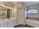 Bathroom with double sinks, bathtub and walk-in shower, all with white cabinets at 1901 Paper Birch Cv, Grayson, GA 30017