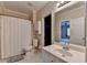 Bright bathroom features a vanity with mirror, storage cabinet, and shower curtain at 1901 Paper Birch Cv, Grayson, GA 30017