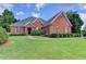 Beautiful brick home with a well-manicured lawn and mature landscaping under a bright blue sky at 1901 Paper Birch Cv, Grayson, GA 30017
