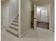 Inviting hallway with carpeted stairs and an open doorway to another room at 1901 Paper Birch Cv, Grayson, GA 30017
