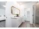 Dual sink bathroom with marble counters, a gold mirror, and a tiled shower with glass doors at 2106 Remy Ct, Kennesaw, GA 30144