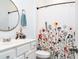 Bright bathroom featuring a vanity, round mirror and floral shower curtain creating a fresh and inviting space at 2106 Remy Ct, Kennesaw, GA 30144