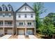 Charming townhouse with white siding, stone accents, and a welcoming covered porch perfect for enjoying the outdoors at 2106 Remy Ct, Kennesaw, GA 30144