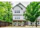 Charming townhouse with white siding and a stone-accented porch, complemented by lush greenery for a serene setting at 2106 Remy Ct, Kennesaw, GA 30144
