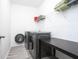 Functional laundry room equipped with a washer, dryer, shelf, and a folding table at 2106 Remy Ct, Kennesaw, GA 30144