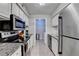 Galley kitchen featuring granite countertops, stainless steel appliances, and a view of the laundry area at 5149 Roswell Rd # 7, Atlanta, GA 30342