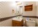 Small bathroom featuring patterned wallpaper, a mirror, and a compact toilet and sink at 5425 Windswept Trce, Sugar Hill, GA 30518
