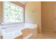 Bright bathroom with a large soaking tub, a large window, and a neutral color scheme at 5425 Windswept Trce, Sugar Hill, GA 30518