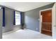 Bedroom with gray walls, two large windows with blinds, and access to an upstairs hallway at 5425 Windswept Trce, Sugar Hill, GA 30518