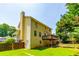 Exterior view of the two-story yellow house with a backyard at 5425 Windswept Trce, Sugar Hill, GA 30518