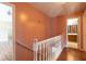 Upstairs hallway with wood floors, a railing, and access to the bathroom at 5425 Windswept Trce, Sugar Hill, GA 30518