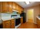 Kitchen with wood cabinets, black appliances, and white countertops, providing a classic and functional design at 5425 Windswept Trce, Sugar Hill, GA 30518