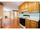 View of the kitchen featuring wooden cabinets, and black appliances, all blending into a cozy space at 5425 Windswept Trce, Sugar Hill, GA 30518