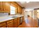 Classic kitchen sink under a bright window, with oak cabinets and black appliances in the background at 5425 Windswept Trce, Sugar Hill, GA 30518