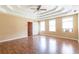 Large main bedroom with tray ceilings, ceiling fan, and hardwood floors at 5425 Windswept Trce, Sugar Hill, GA 30518