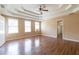 Spacious main bedroom with tray ceilings, a ceiling fan, and windows at 5425 Windswept Trce, Sugar Hill, GA 30518