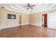 Spacious main bedroom with tray ceilings, a ceiling fan, and an open doorway at 5425 Windswept Trce, Sugar Hill, GA 30518