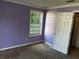 Bedroom with violet painted walls features a large window and door to closet at 621 Ridge Creek Dr, Clarkston, GA 30021