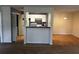 Open dining area adjacent to kitchen with tiled breakfast bar and hardwood flooring at 621 Ridge Creek Dr, Clarkston, GA 30021