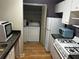 Functional kitchen boasts compact laundry area, gas stove, and modern microwave oven at 621 Ridge Creek Dr, Clarkston, GA 30021