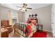 Bedroom with floral bedspread, window with natural light, and ceiling fan at 1070 Cureton Dr, Austell, GA 30106