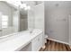 Bright bathroom with a double sink, white cabinets, large mirror, a bathtub, and wood-look flooring at 11827 Spring Lake Way, Fayetteville, GA 30215