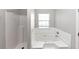 Bathroom features tiled shower and tub next to the window at 11827 Spring Lake Way, Fayetteville, GA 30215