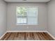 Bedroom with large window for natural light, showcasing hardwood floors and neutral walls at 11827 Spring Lake Way, Fayetteville, GA 30215