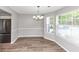 The dining area features new flooring, lots of natural light, stainless fridge and a modern chandelier at 11827 Spring Lake Way, Fayetteville, GA 30215