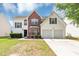 Charming two-story home featuring a brick facade, white siding, a two-car garage, and a well-manicured front yard at 11827 Spring Lake Way, Fayetteville, GA 30215