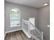 Staircase featuring hardwood floors, white railing and an arched window that provides natural light at 11827 Spring Lake Way, Fayetteville, GA 30215