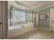 Bright bathroom featuring a soaking tub, shower, and elegant tile flooring at 1320 Kildare Ct, Snellville, GA 30078
