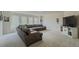 Living room with a large grey couch, several windows, and carpeted floors at 1320 Kildare Ct, Snellville, GA 30078