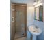Bathroom featuring a shower stall, pedestal sink, vanity mirror, and bright lighting at 1376 Woodbine St, Marietta, GA 30062