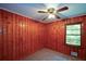 Cozy bedroom features unique wood paneling, a ceiling fan, and a bright window view at 1376 Woodbine St, Marietta, GA 30062