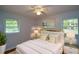 Bright bedroom with light walls, a ceiling fan, plush bedding, and a lovely house plant at 1376 Woodbine St, Marietta, GA 30062