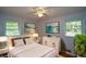 Comfortable bedroom featuring light-colored walls, ceiling fan, neutral decor and natural light at 1376 Woodbine St, Marietta, GA 30062