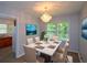 Bright dining room with a modern table set, chandelier, and large windows overlooking lush greenery at 1376 Woodbine St, Marietta, GA 30062