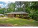 Traditional brick home with neat landscaping, shutters, and mature trees providing shade on a sunny day at 1376 Woodbine St, Marietta, GA 30062