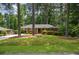 Brick home with mature trees, green lawn, and carport on a sunny day at 1376 Woodbine St, Marietta, GA 30062