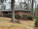 This brick home offers a serene landscape with mature trees and manicured greenery at 1376 Woodbine St, Marietta, GA 30062