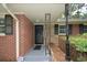 Close-up of brick front porch with black wrought iron details, a security system sign, and stone accents at 1376 Woodbine St, Marietta, GA 30062