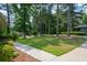 Corner lot featuring a green lawn, mature trees, and a sidewalk leading to the street at 1376 Woodbine St, Marietta, GA 30062