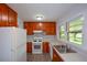 Spacious kitchen featuring wood cabinetry, white appliances, and abundant natural light at 1376 Woodbine St, Marietta, GA 30062