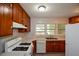 Traditional kitchen with wooden cabinets, a white gas range, and a stainless steel sink at 1376 Woodbine St, Marietta, GA 30062