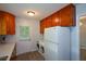 Combined laundry area with wooden cabinets and a side-by-side washer and dryer set at 1376 Woodbine St, Marietta, GA 30062