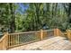 Expansive back deck with wooden railing overlooking a scenic backyard filled with trees at 2537 Baker Nw Rd, Atlanta, GA 30318
